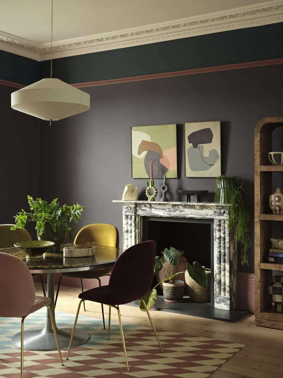 Dark espresso interior with vintage seating, graphic prints and warm accent colours