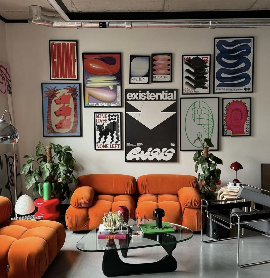 Orange modular seating, a glass coffee table and a colourful gallery wall